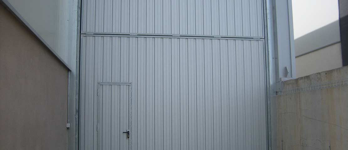 puertas industriales contrapesada basculante3 1110x480 - Reparación Persianas Puertas Naves Industriales Barcelona