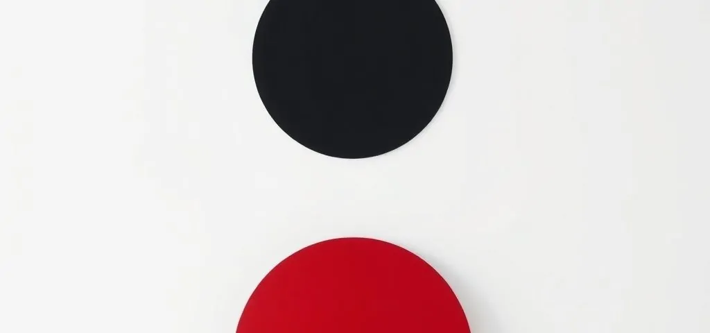 Círculo negro centrado con semicirculo carmesí en un fondo blanco, simbolizando "Cuales son las opciones mas eficientes para la motorizacion de persianas en Barcelona".