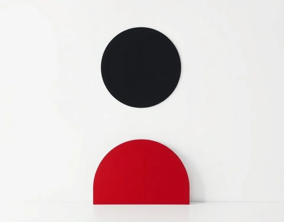 Círculo negro centrado con semicirculo carmesí en un fondo blanco, simbolizando "Cuales son las opciones mas eficientes para la motorizacion de persianas en Barcelona".